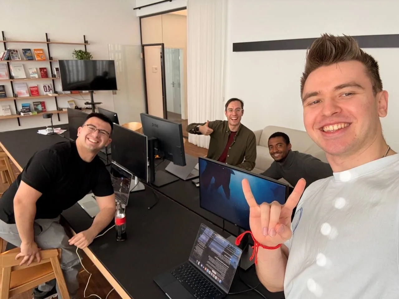 Vier Teilnehmer des GTM Hackathon an einem Tisch mit Laptops und Monitoren