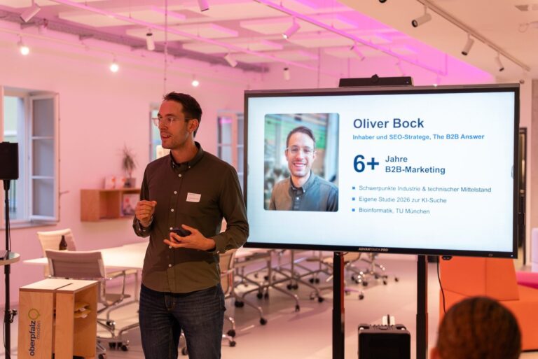 Oliver Bock stellt sich beim INSIGHTS+ in Amberg vor, im Hintergrund die Folie mit sechs Jahren B2B-Marketing